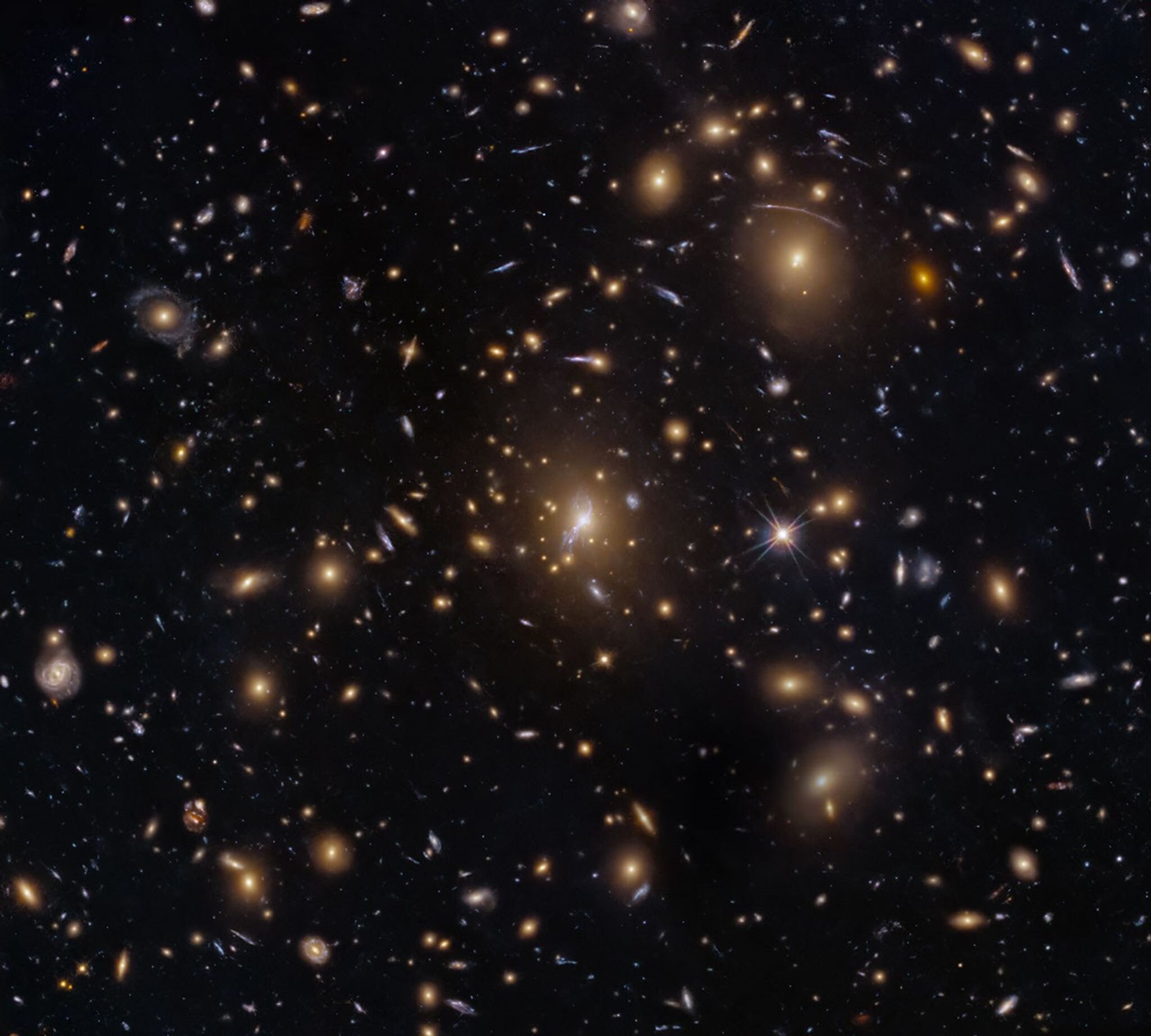 Hubble quan sát một cụm thiên hà từ giai đoạn sớm của vũ trụ nhờ thấu kính hấp dẫn